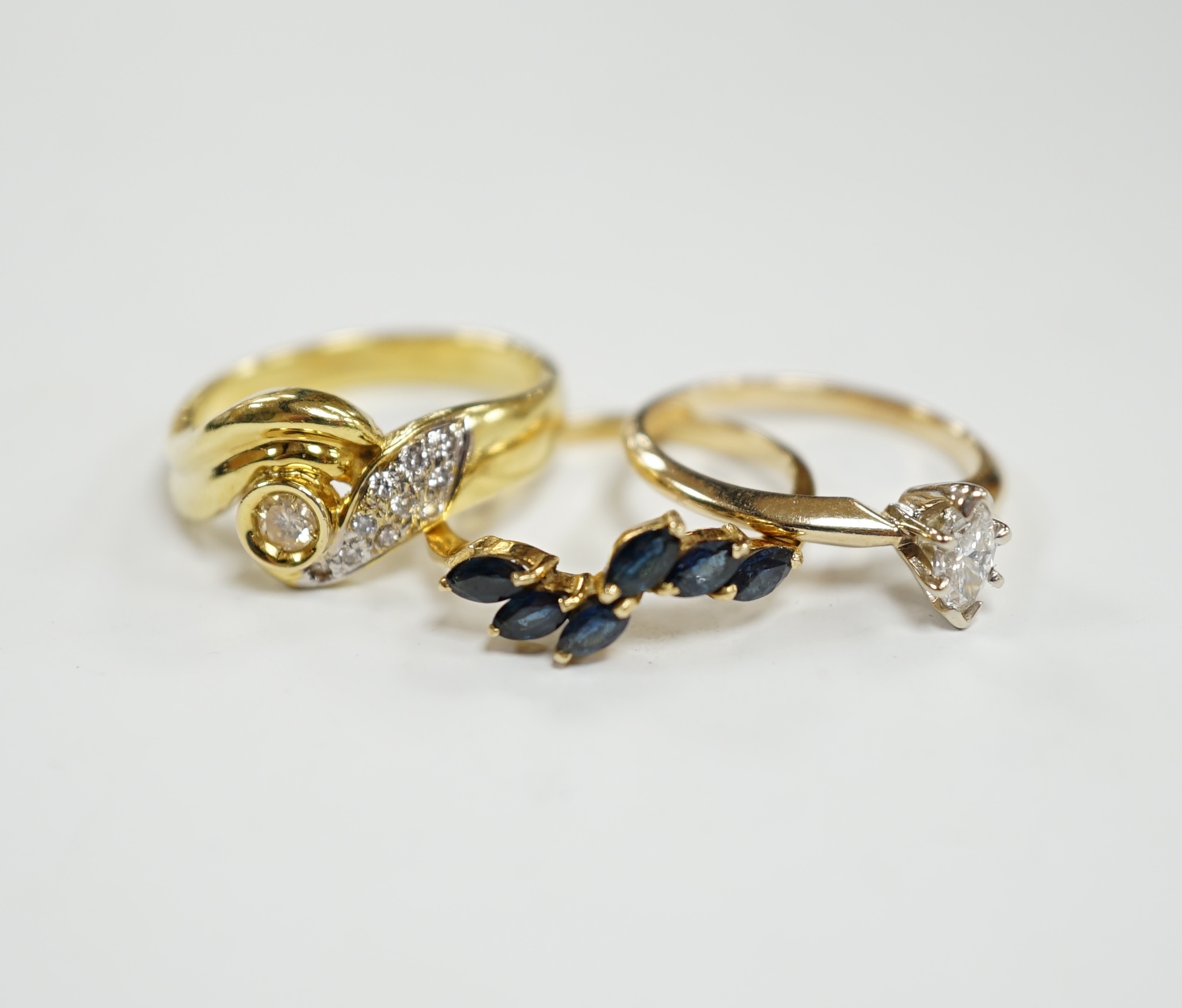 Three assorted modern 14k and gem set rings, including single stone marquise cut diamond, diamond chip set and sapphire set, gross weight 7.7 grams.